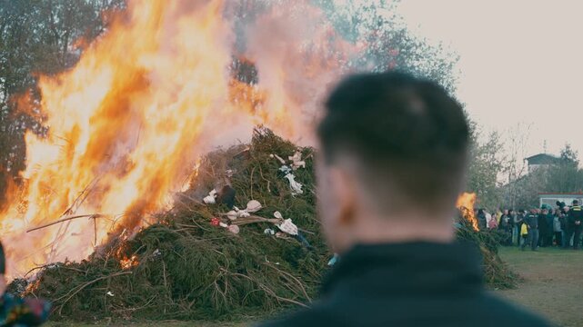 Man standing with burning bonfire in background during spring festival near Liberec Czech Republic Europe