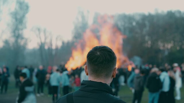 Man standing with burning bonfire in background during spring festival near Liberec Czech Republic Europe
