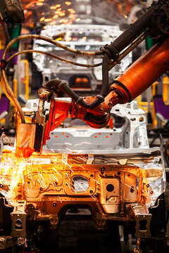 Robotic arms are welding on an automated car production line.