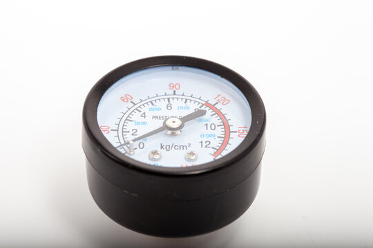 Close-up of a professional black analog pressure gauge with white dial displaying measurements in kg/cm&sup2;, kPa (BAR), and PSI (Lb/in&sup2;). The needle points to approximately 9 kg/cm&sup2;. Essential industrial
