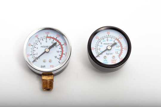 Close-up of a professional black analog pressure gauge with white dial displaying measurements in kg/cm&sup2;, kPa (BAR), and PSI (Lb/in&sup2;). The needle points to approximately 9 kg/cm&sup2;. Essential industrial