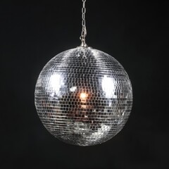 Obraz premium Reflective sphere on chain, emitting light against dark backdrop