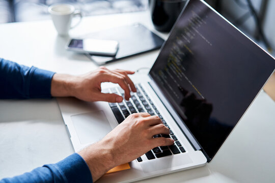 Man vibe coding on laptop at desk close-up