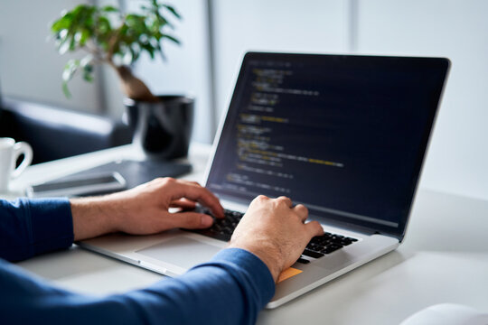 Developer vibe coding on laptop closeup at desk