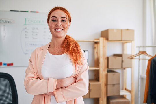 Confident young woman entrepreneur smiling in small business office - portrait