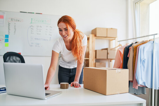 Young woman packing orders in small business clothing shop