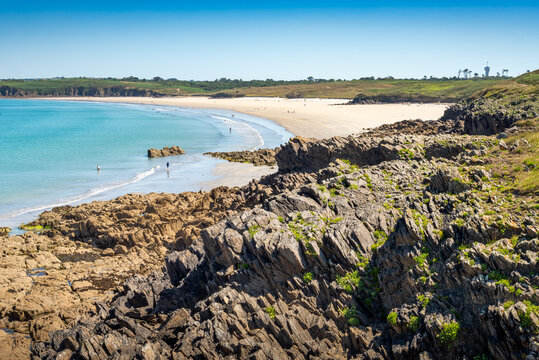 View of Blancs Sablons beach from Pointe de Kermorvan Le Conquet Finistere Brittany France showing rocky foreground, turquoise sea, sandy shore and clear summer sky