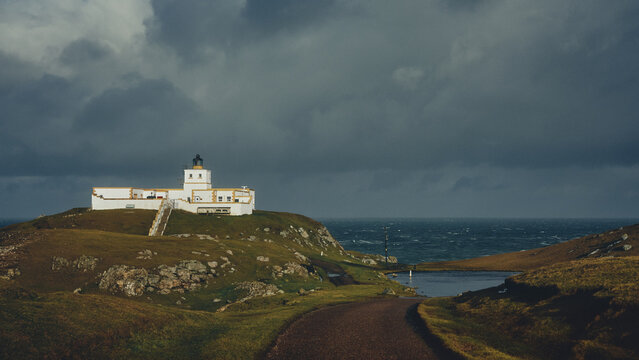 lighthouse on the hill overlooking stormy seas