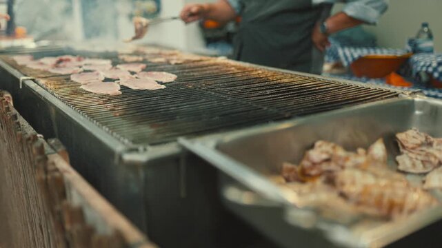 Cooking meat on grill at outdoor event in city during daytime with people nearby enjoying food