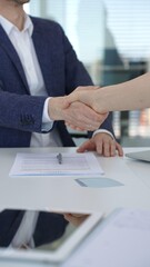 Obraz premium Business people shaking hands over a contract and digital tablet, symbolizing a successful partnership, agreement, and closing a deal during a corporate meeting in an office setting