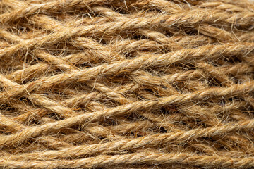 Fototapeta premium Extreme close-up of natural jute rope texture background,Macro,A detailed macro shot showing the intricate texture and fibrous strands of a coiled natural jute rope. The warm brown tones and organic.