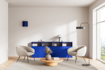 Fototapeta premium Modern interior lounge with beige chairs, bold blue cabinet, rounded wooden table, floor lamp and soft daylight forming a calm contemporary design scene. 3D Rendering