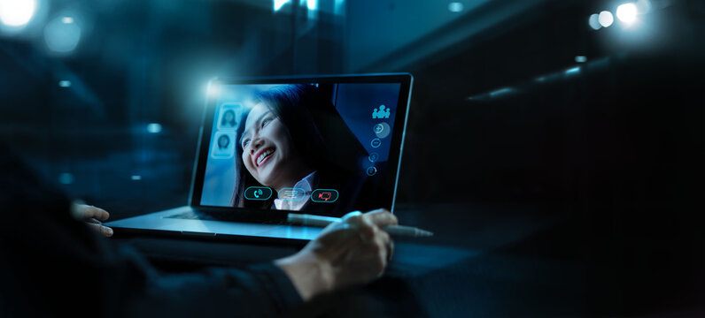 Businessman having a video call with coworker of Asian businesswoman with remote team using laptop and camera, Virtual video conference meeting, Social distancing, Working online from home concept.