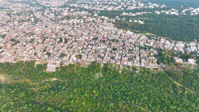 Cinematic Drone shot showing overpopulated city limits encroaching on nature. his smooth, creeping camera movement visually represents the relentless march of urban encroachment, overpopulation.