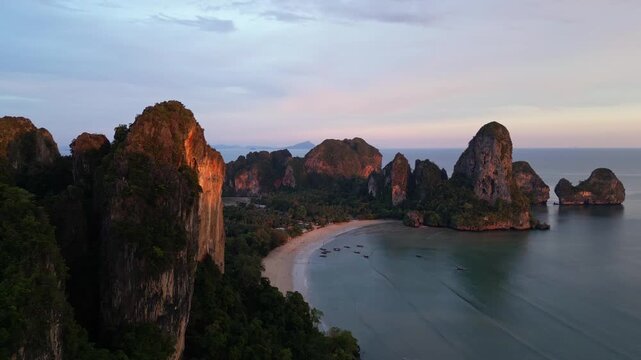 Krabi, Thailand: Aerial drone footage of the dramatic sunset over the limestone landscape of Railay, or Raliey beach in Krabi in Thailand by the Andaman sea. Shot with a rotation motion. 