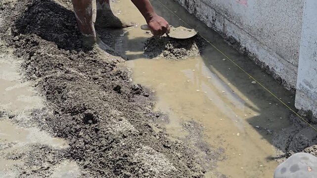 Workers align tight string lines over mortar mounds to set accurate slope levels for slab waterproofing. This initial step secures direct water drainage, preventing pooling risks and structural leaks.