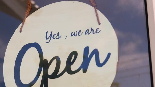 An Open sign with text Yes, we are inviting potential customers