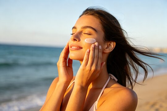 Woman applying sunscreen on beach