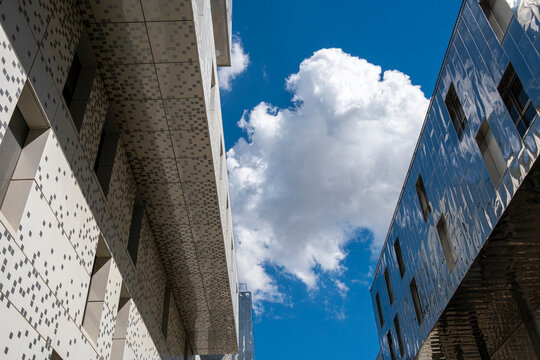 A concrete facade frames an urban angle where reflection, cloud and sky open between architecture in Lyon, France, with strong vertical contrast