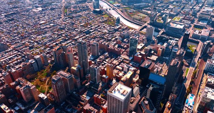 Dense urban landscape of modern Philadelphia, Pennsylvania, USA. Drone footage approaching the river crossing the city.