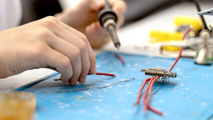 Obraz premium Hands steady wires on a blue workbench