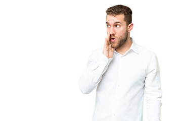 Fototapeta premium Young handsome blonde man over isolated chroma key background whispering something with surprise gesture while looking to the side