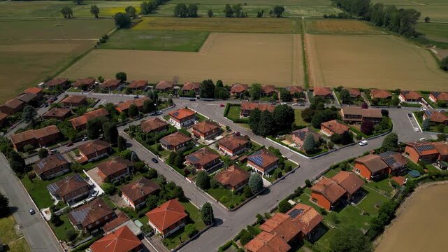 Suburban Serenity from Above: An aerial view showcases a neat suburban neighborhood with rows of charming houses, neatly paved streets, and green spaces.