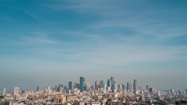 Panoramic view of a modern city skyline under a vast, clear blue sky, showcasing numerous skyscrapers and urban sprawl
