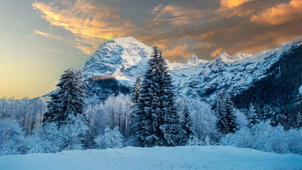 Naklejka premium the sun sets in a spectacular winter scene high in the mountains