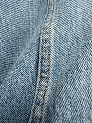 Close-up of blue denim fabric seam with detailed stitching texture, ideal for background use © dvoevnore