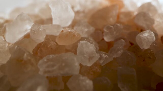 Macro video of pink Himalayan salt crystals falling in slow motion