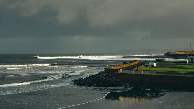 view over stormy seas and sky from the pier at sunrise