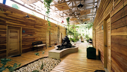 Sustainable architecture and natural design blending a tropical resort with nature. Featuring wooden walls, decking, and a stone fountain © DMegias