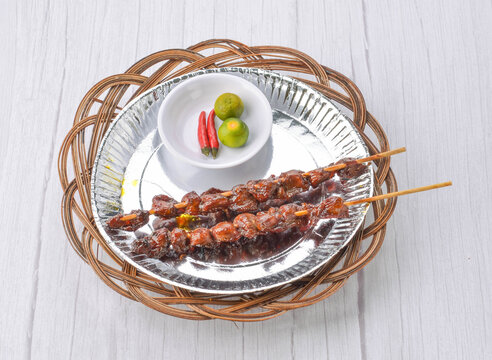 Filipino grilled chicken gizzard skewers served with calamansi and chili