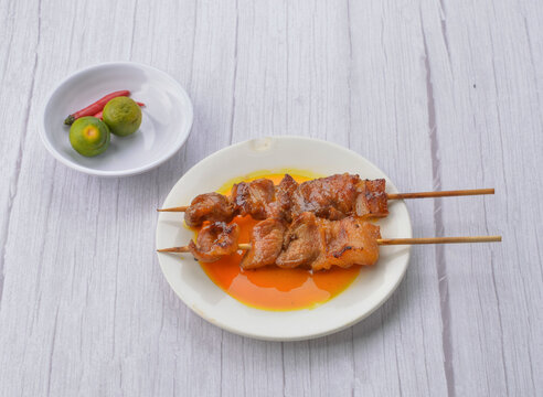 Sweet and savory Filipino pork barbecue skewers served with dipping sauce
