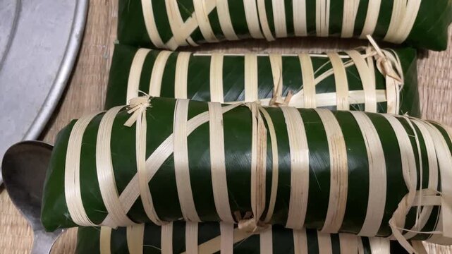 Rows of newly wrapped banh tet in Vietnam, ready to be boiled for Lunar New Year, captured for festive food preparation and cultural tradition footage.