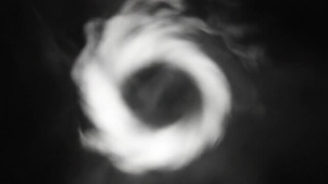 Mesmerizing swirling smoke ring swirling against black background representing creativity and fluidity
