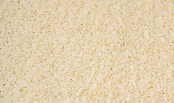 Grated coconut powder. Dry coco flakes pile, shredded desiccated coconut, tropical fruit chips