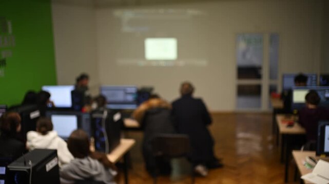 Students gathered in computer lab learning with projector screen and modern technology.