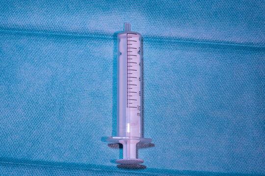 Single Empty 10ml Medical Syringe on Blue Sterile Drape - Professional Healthcare and Nursing Supply