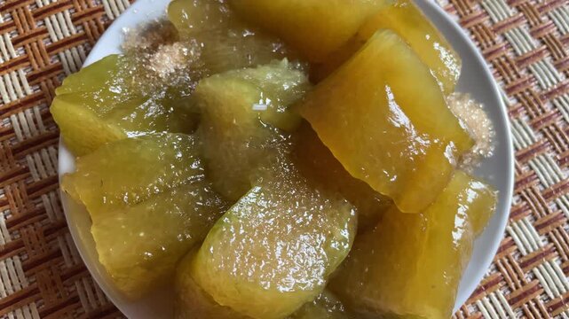 Vietnamese banh tro served on a plate in Vietnam, filmed close-up with translucent rice cake pieces and sugar for traditional dessert and local cuisine themes.