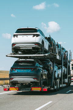 New SUVs transported on truck along highway road