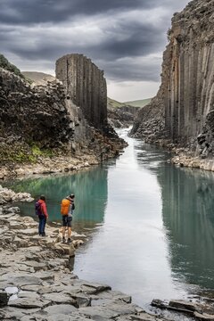 Two tourists in Stu&eth;lagil Canyon, basalt columns, Egilsstadir, Iceland