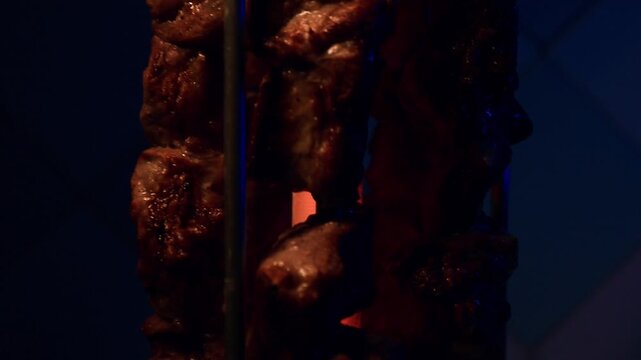 Close up slowmo video of pork pieces cooking on electric barbecue grill in kitchen with detailed food preparation FHD 96 fps