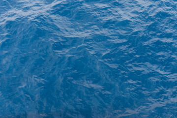 Obraz premium Abstract top view of deep blue sea water surface with gentle ripples and waves, natural aquatic background for summer designs