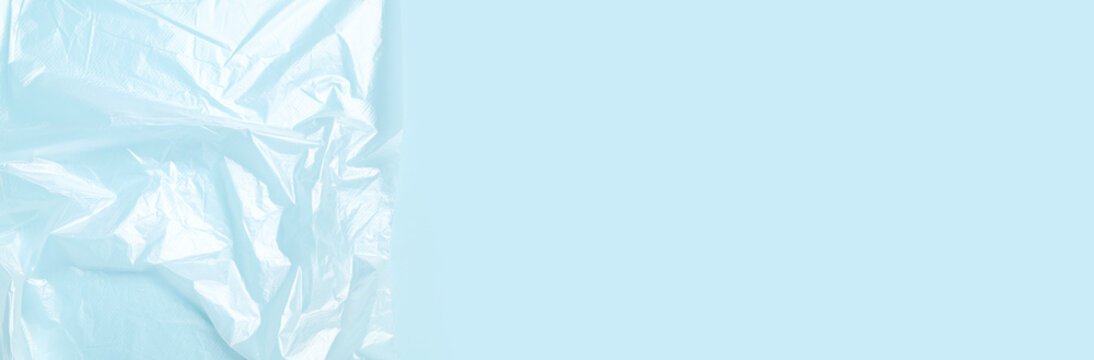 Cling film on blue background. Close-up of texture of wrinkled cling film for storing and packaging food. Abstract background with space for text