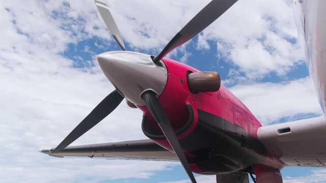Detailed close-up of airplane propeller and engine nacelle against blue sky, highlighting aircraft engineering, aviation technology and propeller aircraft design.