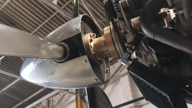 Detailed close-up of aircraft propeller shaft and engine assembly during maintenance procedure, showcasing aviation engineering and airplane propulsion technology.