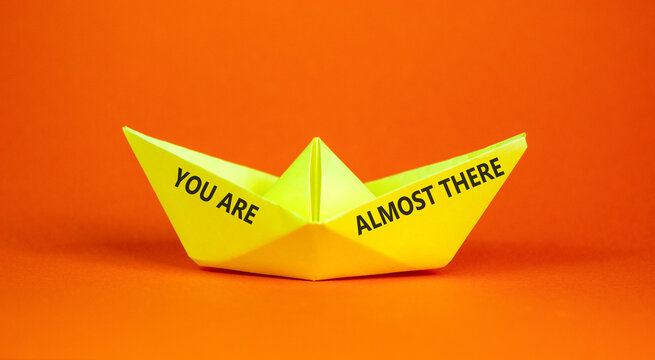 You are almost there words symbol. Concept words You are almost there on beautiful paper boat. Beautiful orange background. Business You are almost there motivational support concept. Copy space.