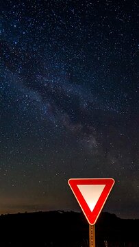 Yield Road Sign Long Exposure Astrophotography Red And White Triangle Standing Under Starry Night With Milky Way Galaxy